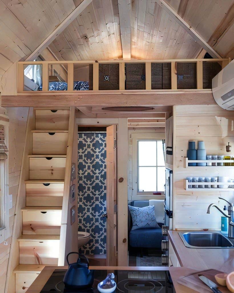 Compact tiny-house interior with storage stairs to a loft