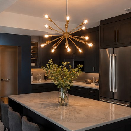 Sculptural brass statement light above a dark kitchen island