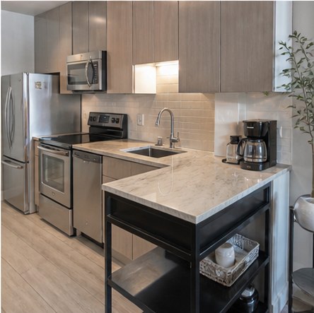 Compact condo kitchen with flat-panel wood cabinets and peninsula